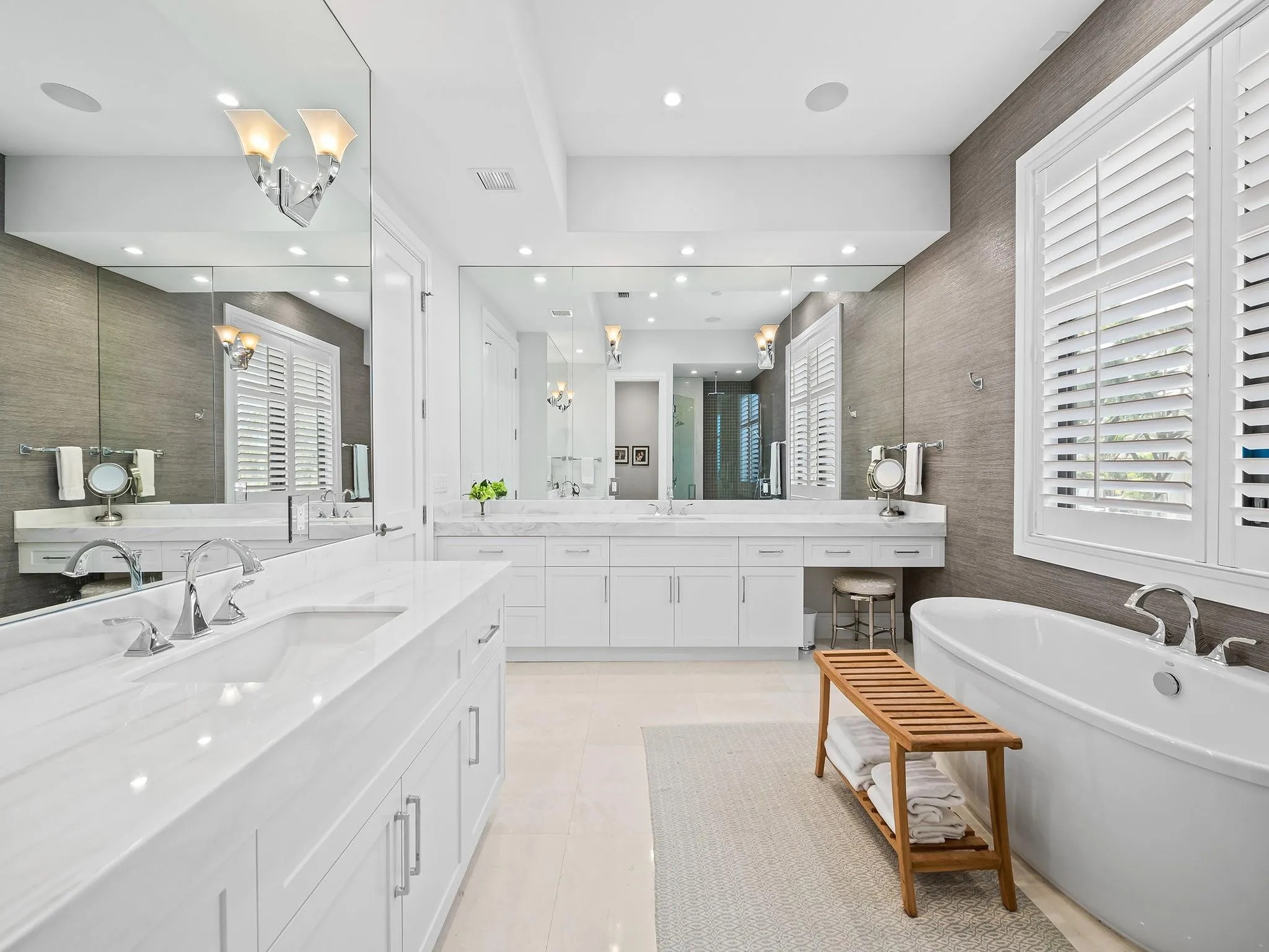 Luxurious primary bathroom, complete with double vanities, a freestanding tub, a private toilet room, and a spacious shower