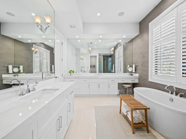 Luxurious primary bathroom, complete with double vanities, a freestanding tub, a private toilet room, and a spacious shower