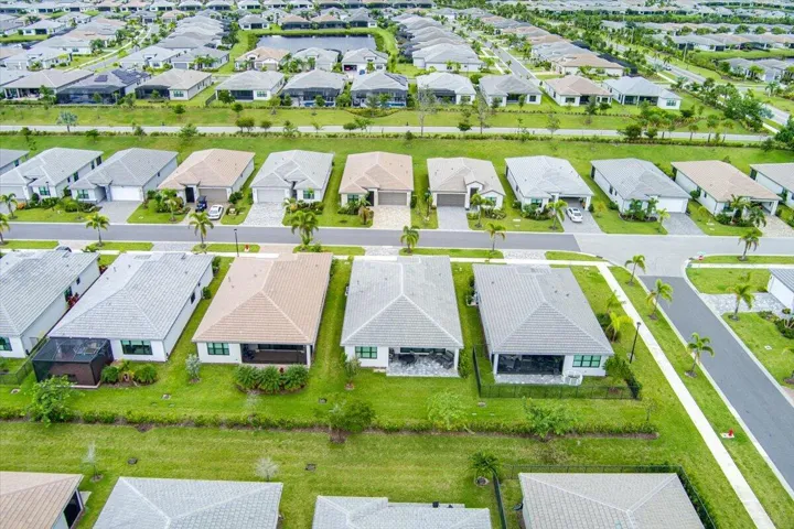 Residential neighborhood with uniform housing styles, paved roadways, and green landscaping