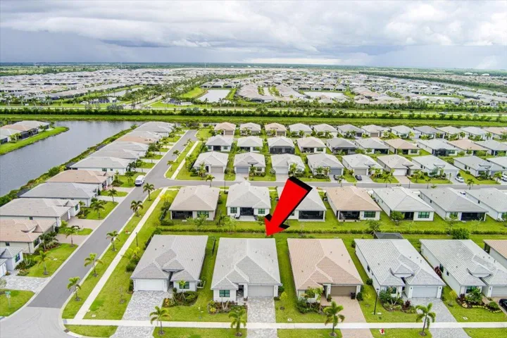 Single-story residence with an attached garage, paver driveway, and manicured lawn