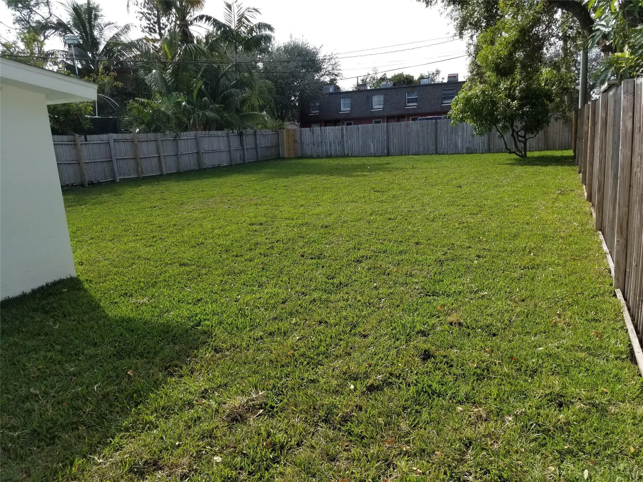 Expansive grass lawn with perimeter wood fencing