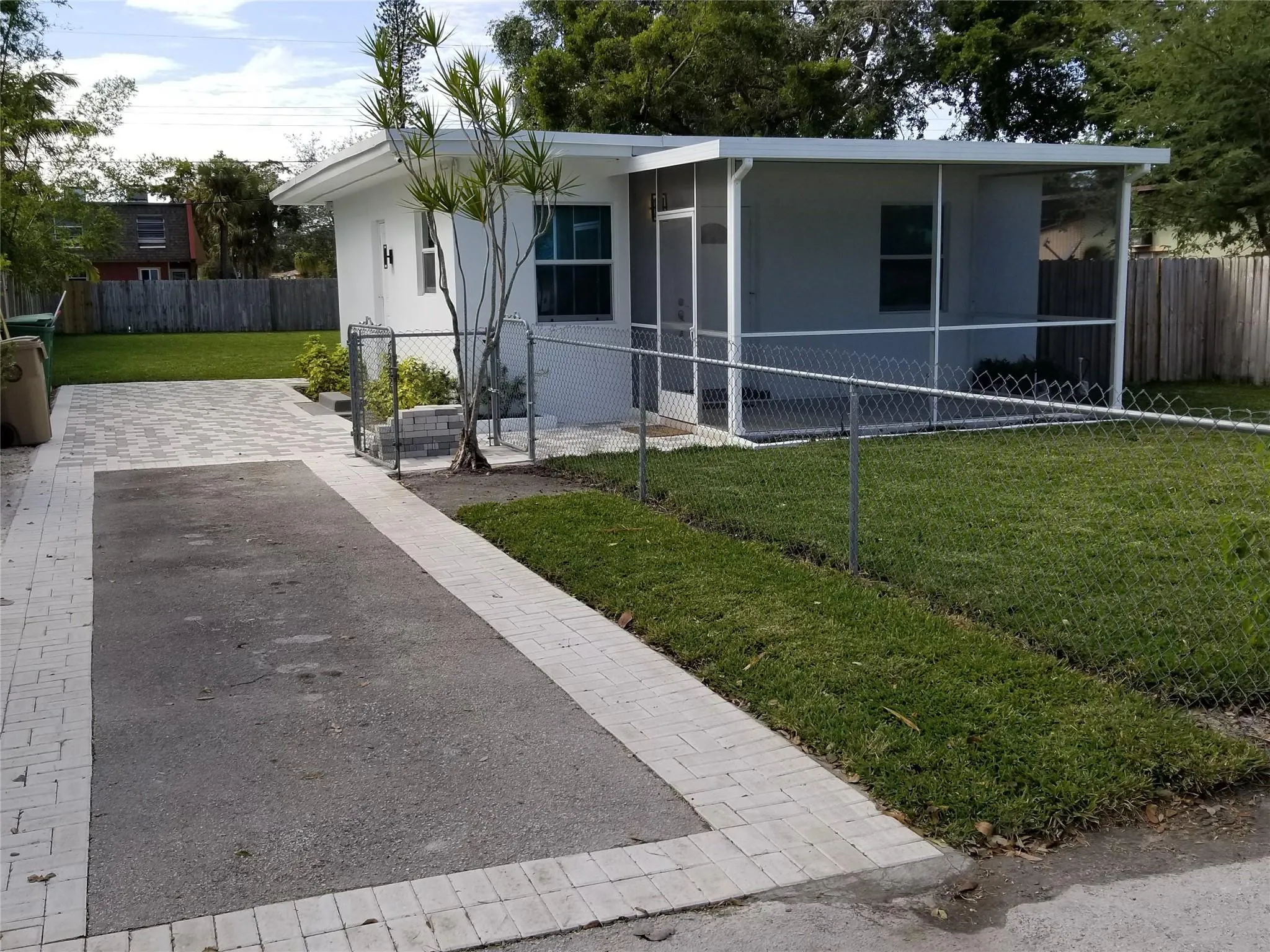 Screend-in porch, paved driveway, chain-link fencing, landscaping