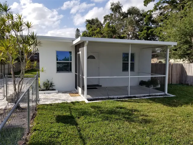 Screened porch with composite decking, white exterior finish, and a chain-link fence