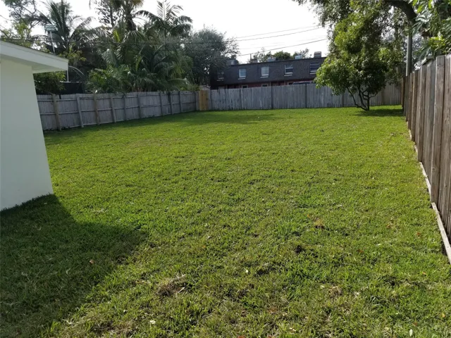 Expansive grass lawn with perimeter wood fencing