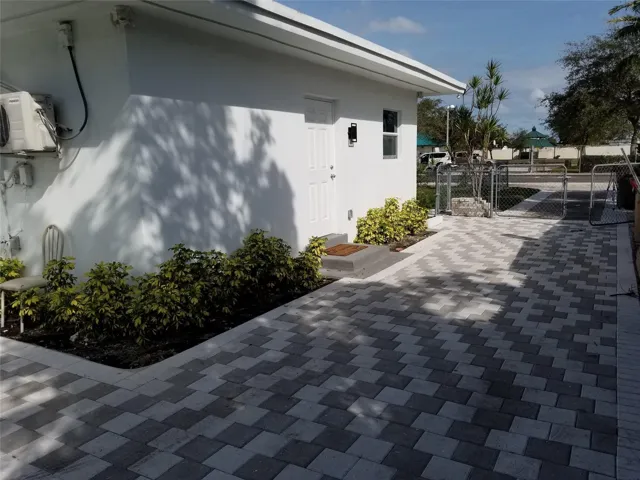 Paved entryway and side yard with a patterned paver design