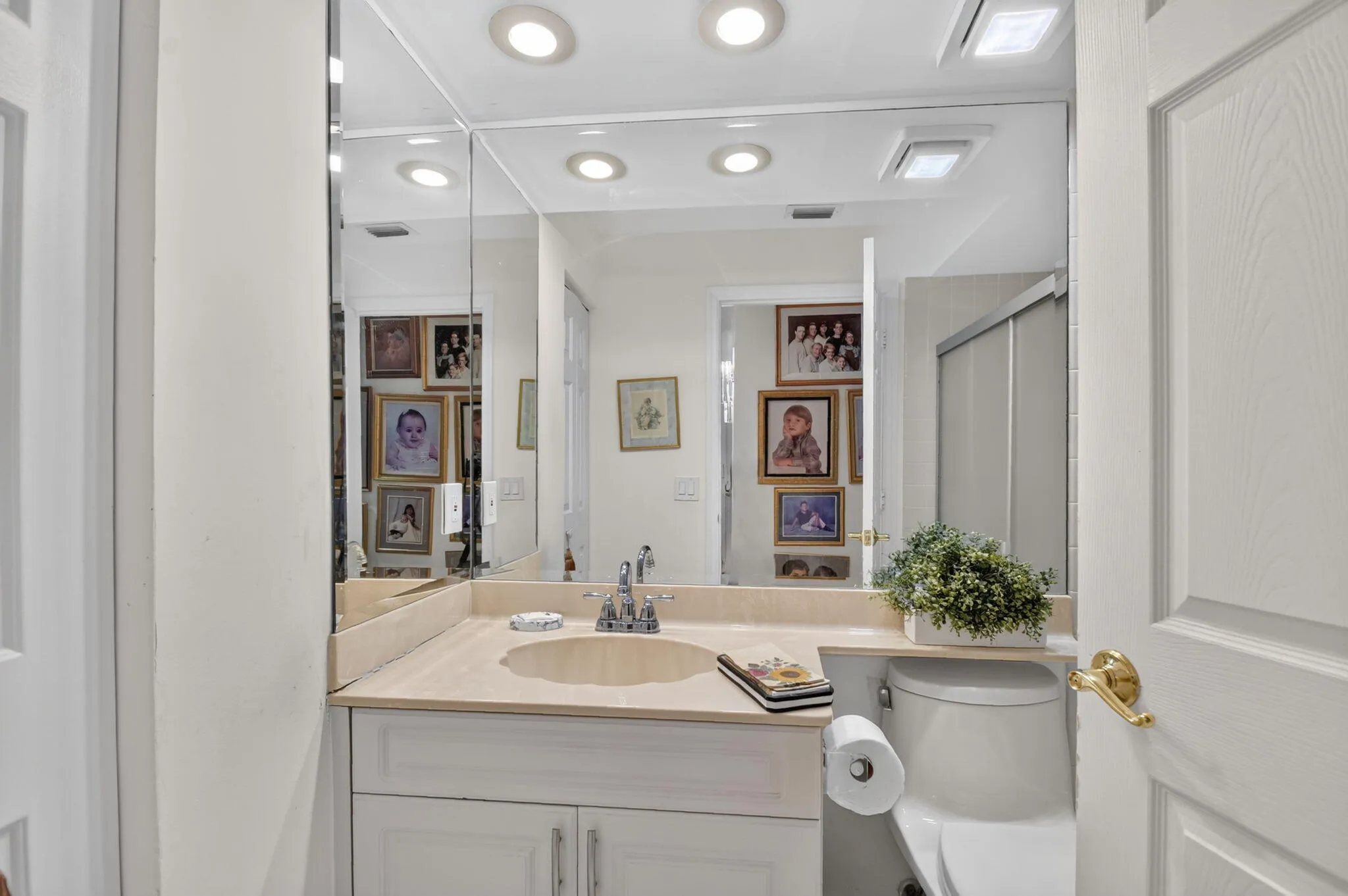 Vanity with an integrated sink, polished chrome faucet, and expansive mirrored wall