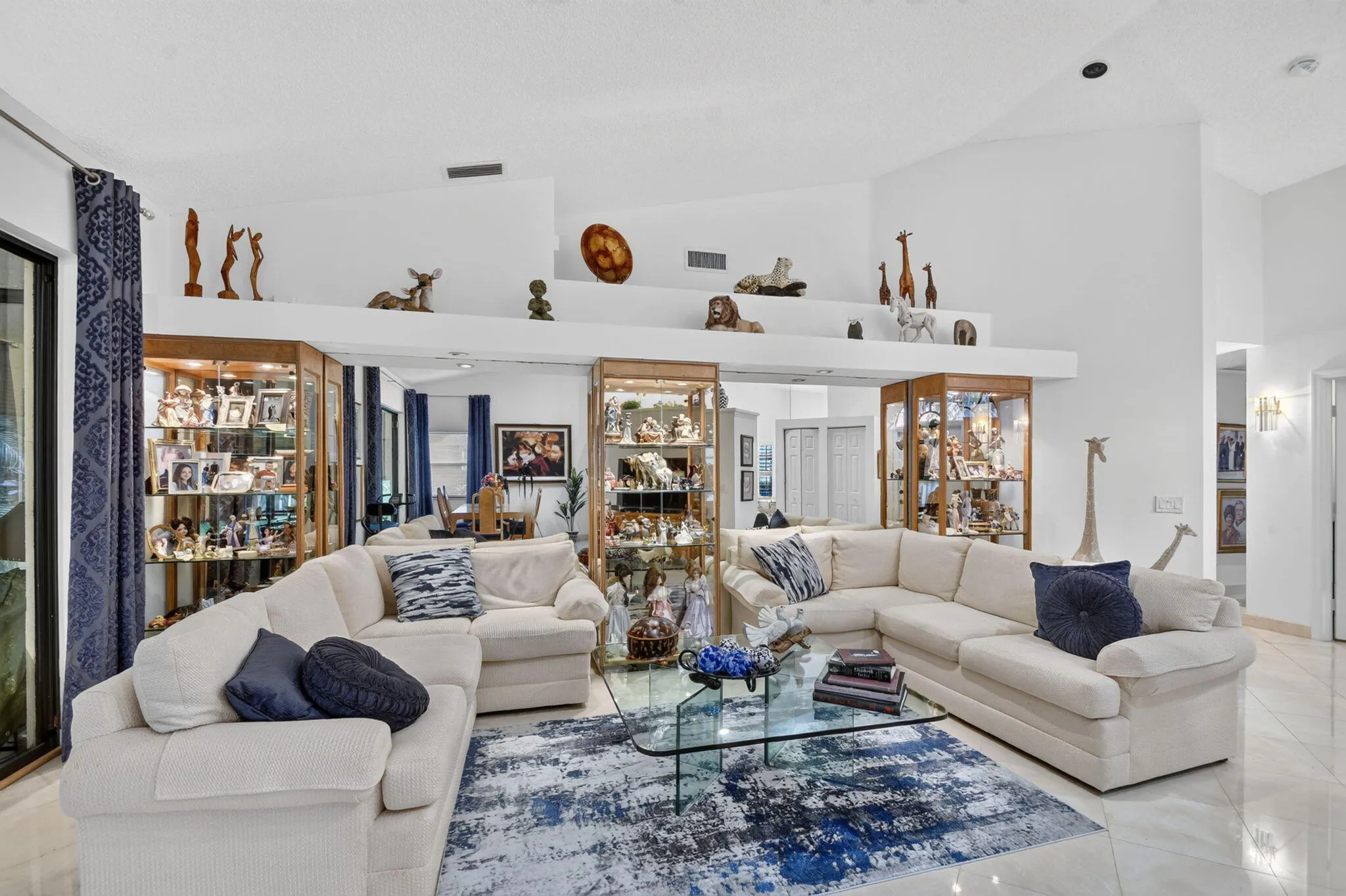 Vaulted ceiling, display shelving, recessed lighting, tile flooring, and integrated display cases