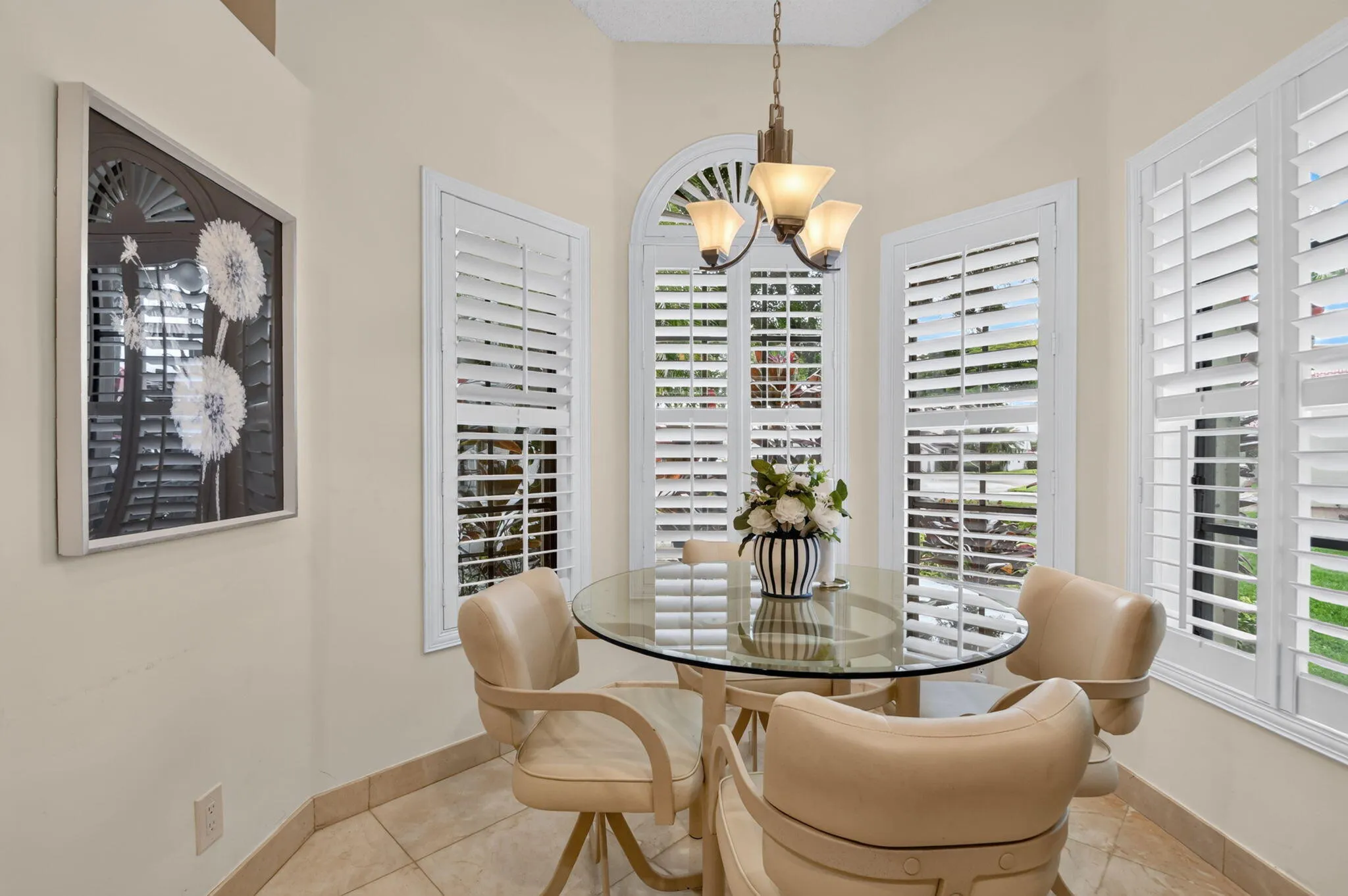Bay window with plantation shutters and an arched transom window