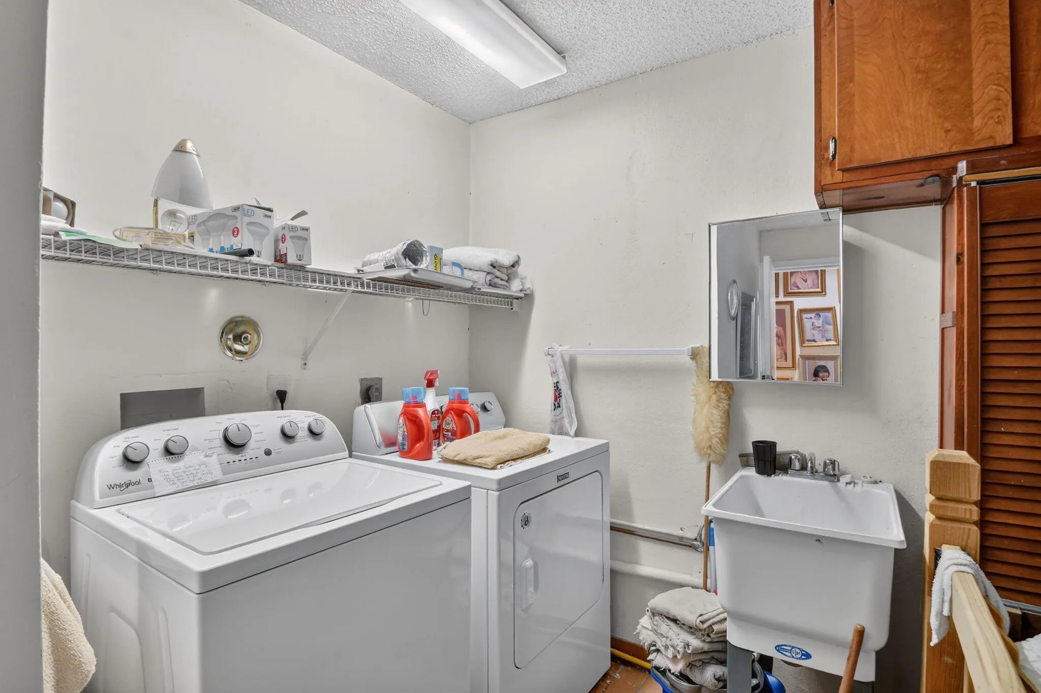 Newer appliances and sink inside of deep one-car garage