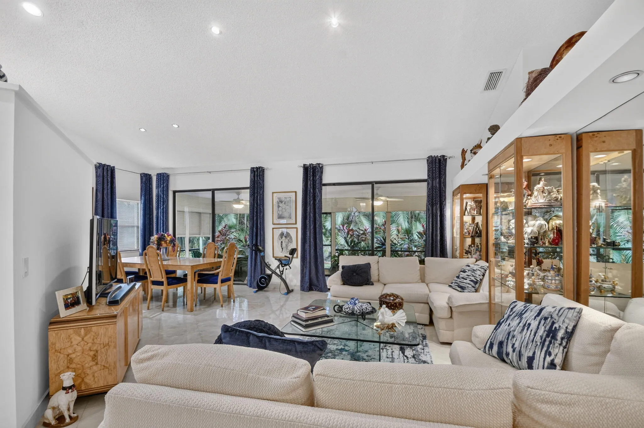 Recessed lighting illuminates the open-concept living space with tile flooring