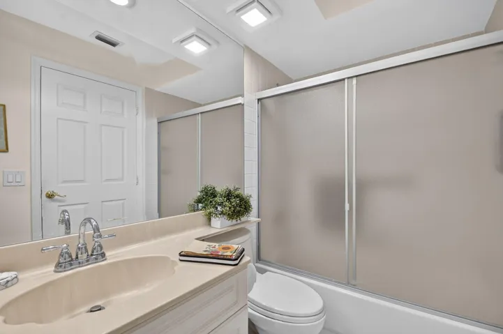 Vanity with an integrated sink, polished chrome faucet, and full-width mirror