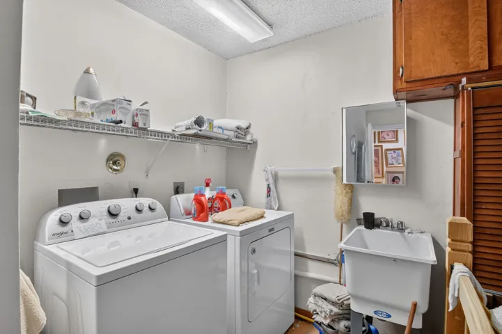 Newer appliances and sink inside of deep one-car garage