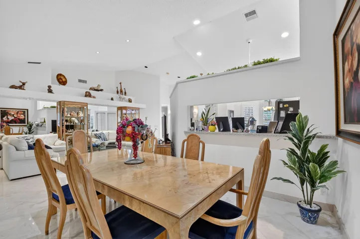 High ceilings with recessed lighting, tile flooring, and a pass-through window with a stone countertop