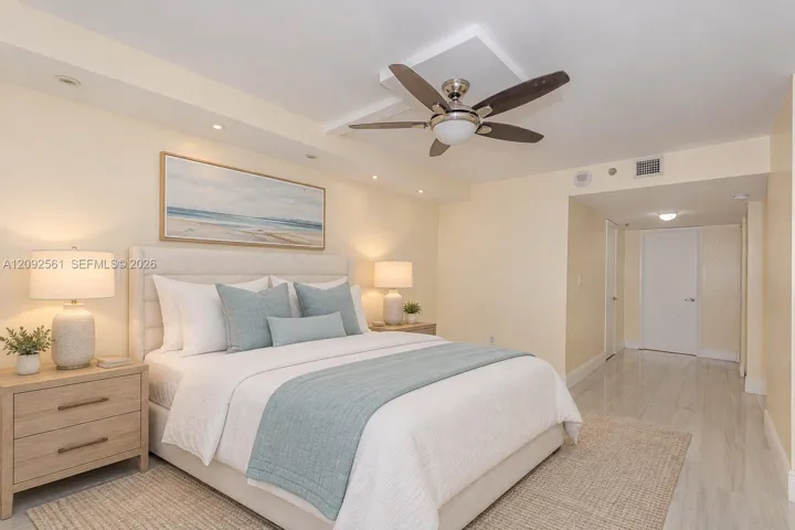Room featuring polished stone-finish flooring, a recessed ceiling accent with integrated recessed lighting, and a multi-blade ceiling fan