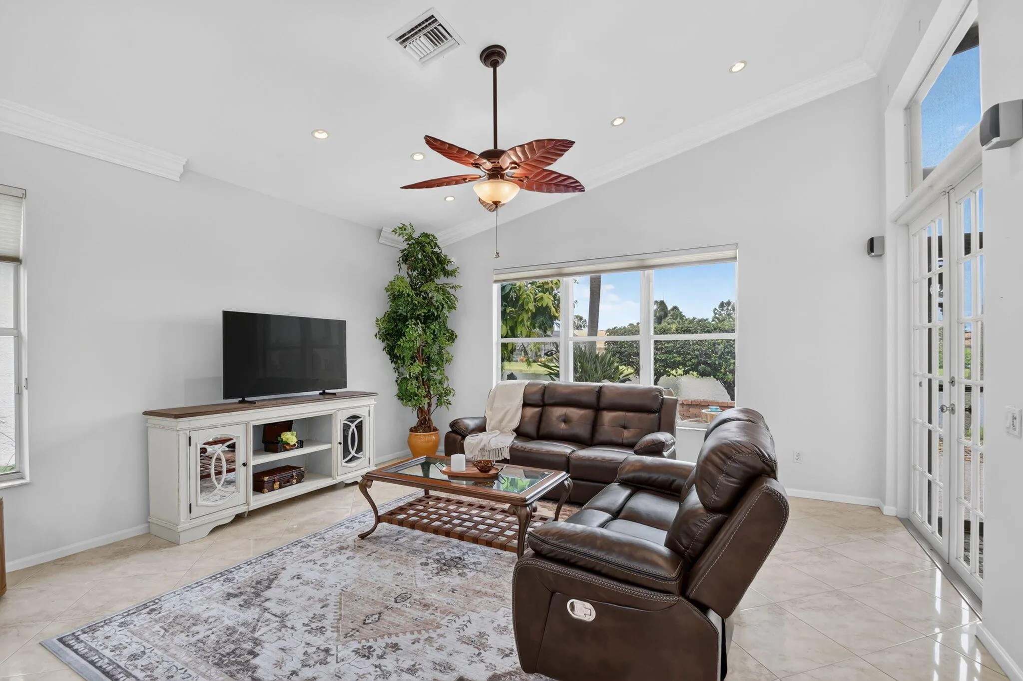 The family room features a vaulted ceiling & a transom window & slider that fills the room with natural light.