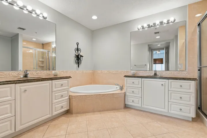 Primary bath features dual vanities, lots of cabinet space, deep soaking tub, and a separate shower.
