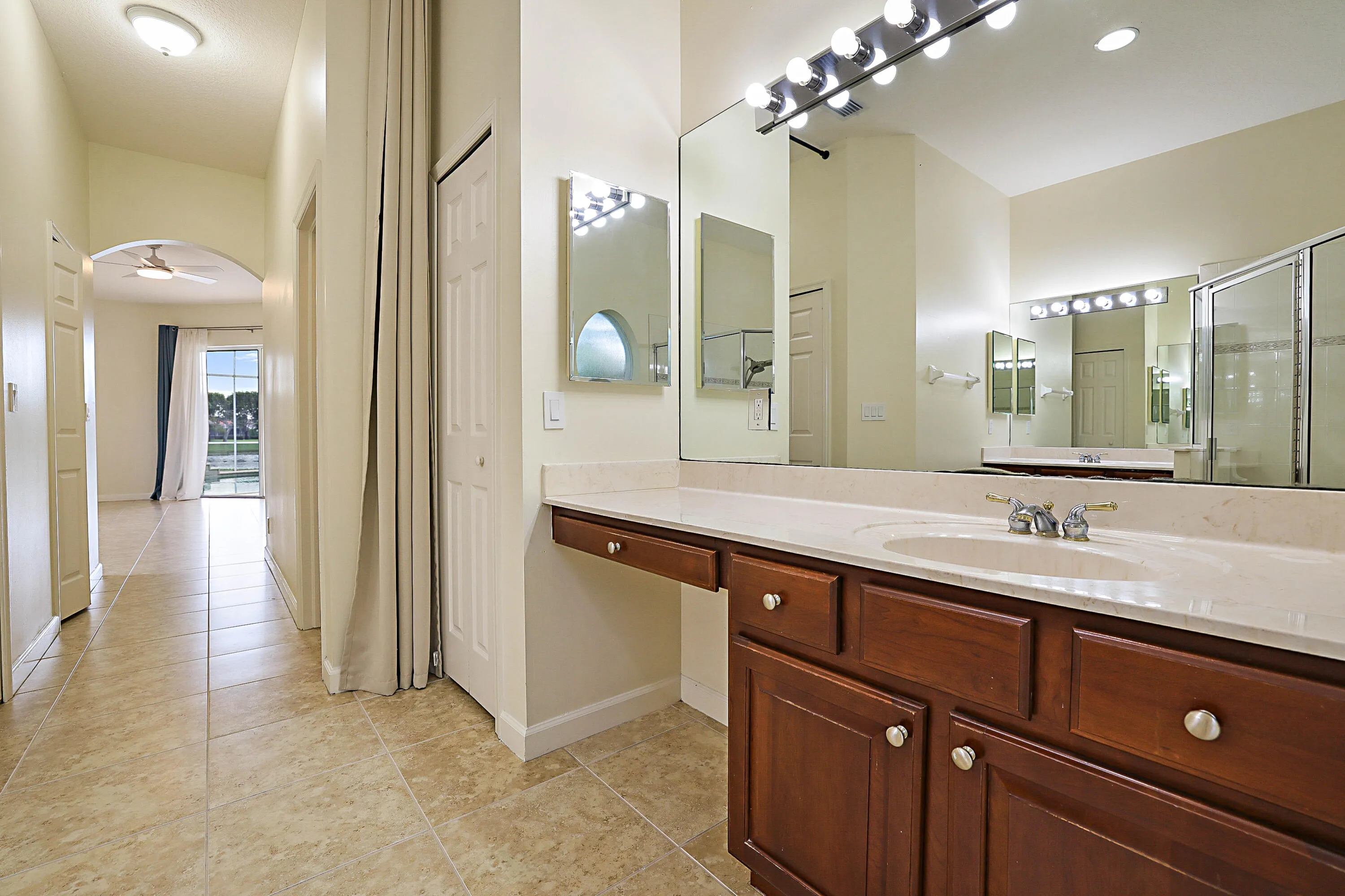 Bathroom vanity with integrated sink, extensive counter space, and wood cabinetry