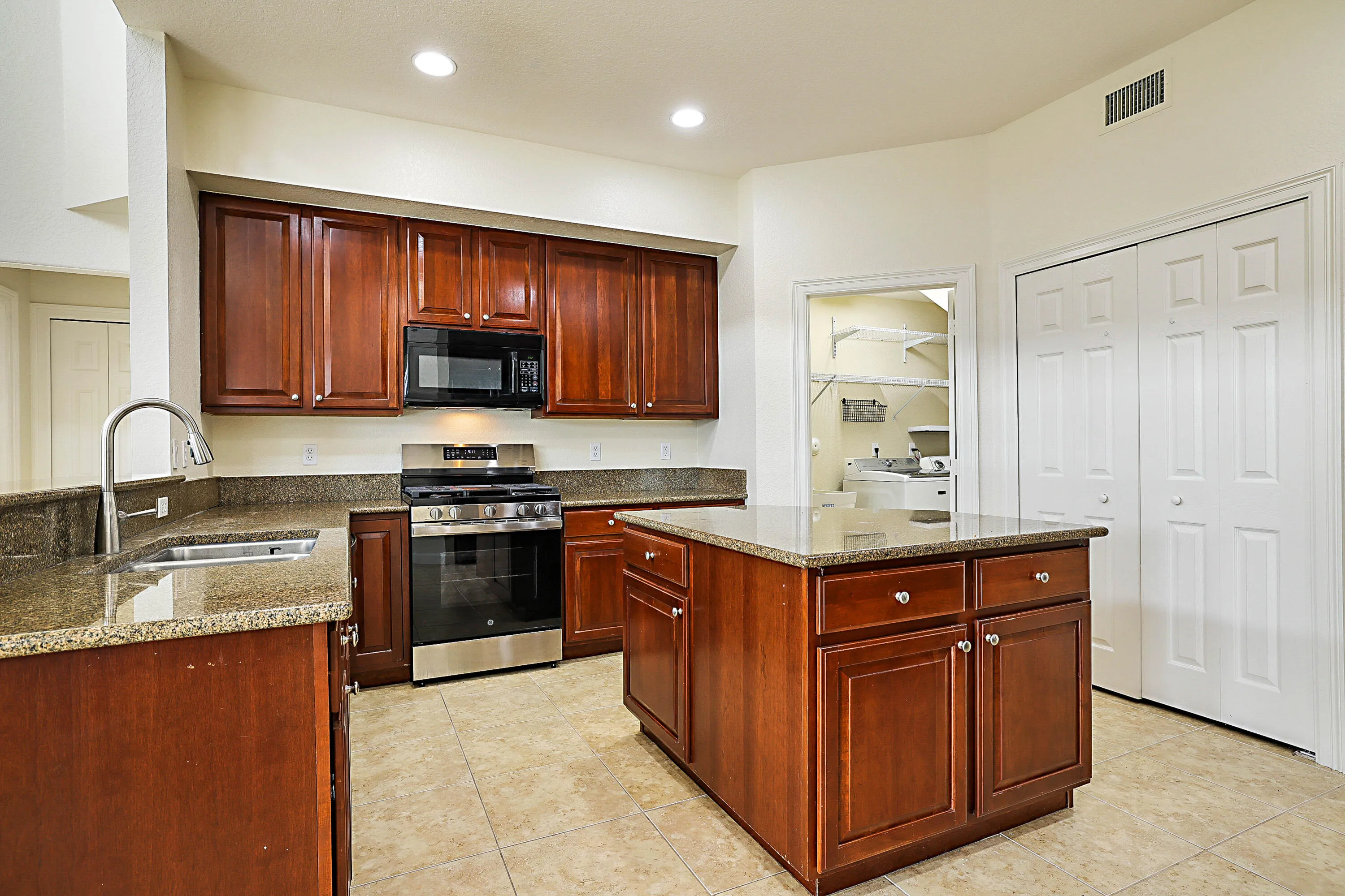 Kitchen featuring an island, recessed lighting, tile flooring, and stainless steel appliances