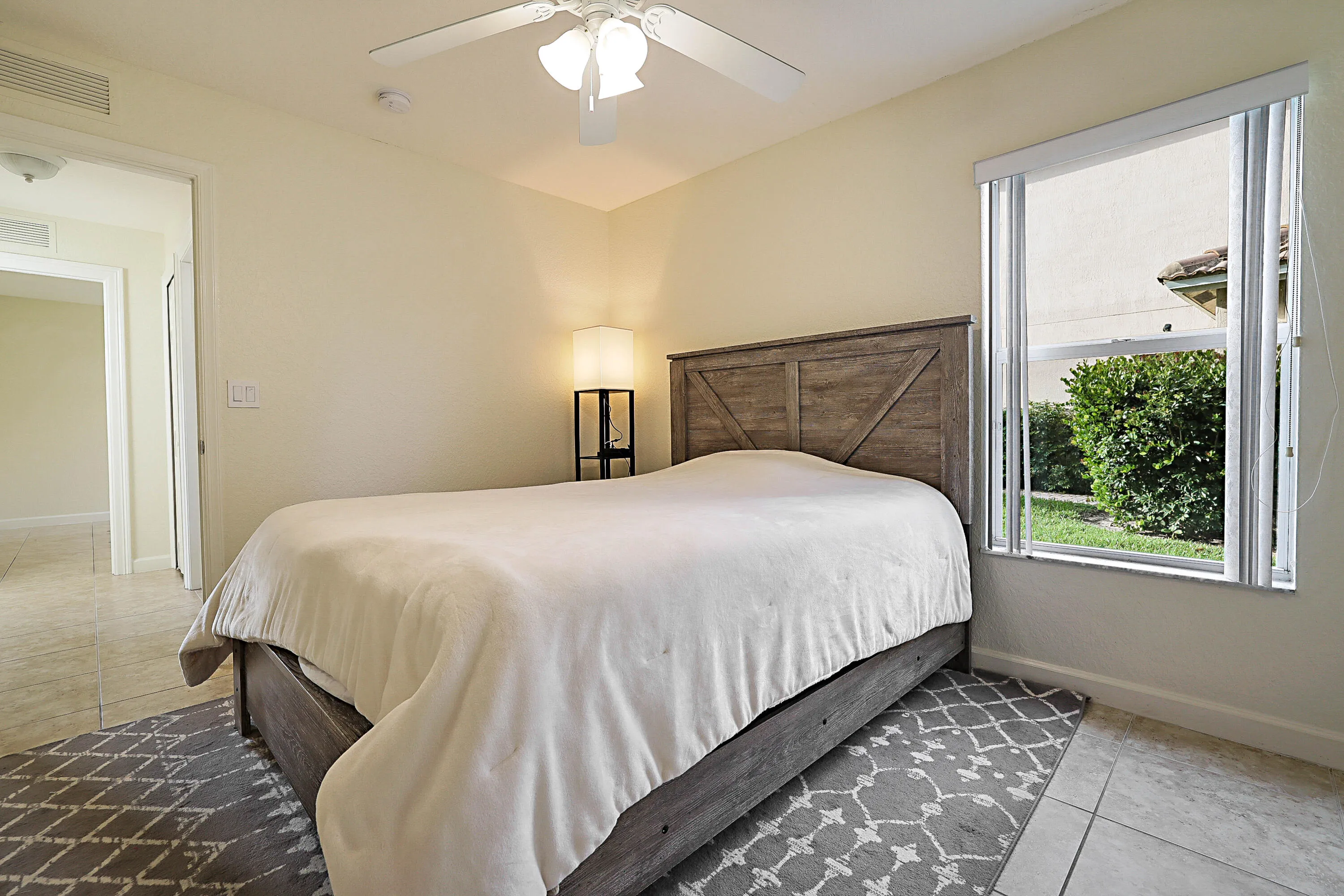 Window with blinds, ceiling fan, and tiled flooring
