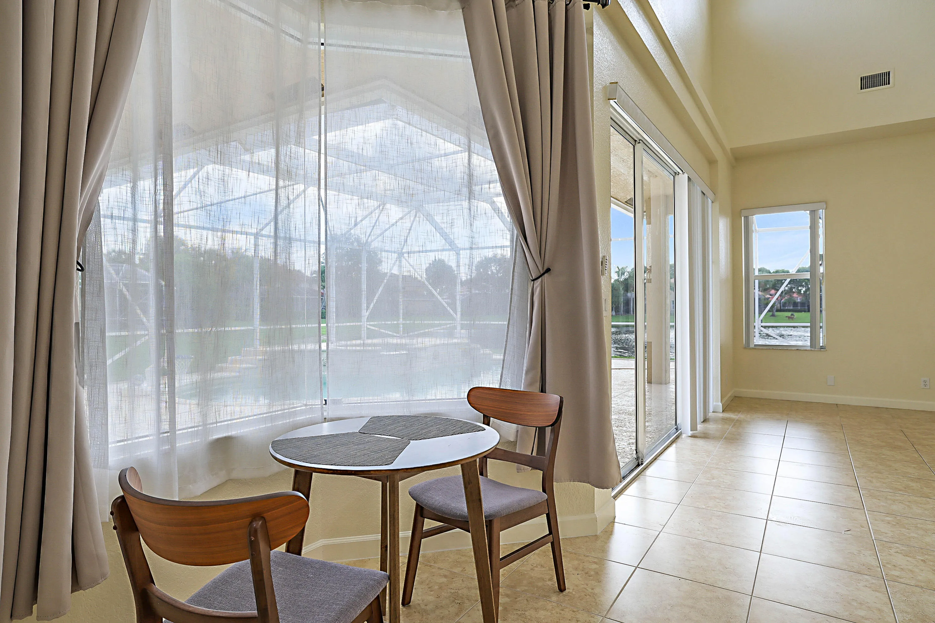 High ceilings, tile flooring, and large windows with privacy sheers