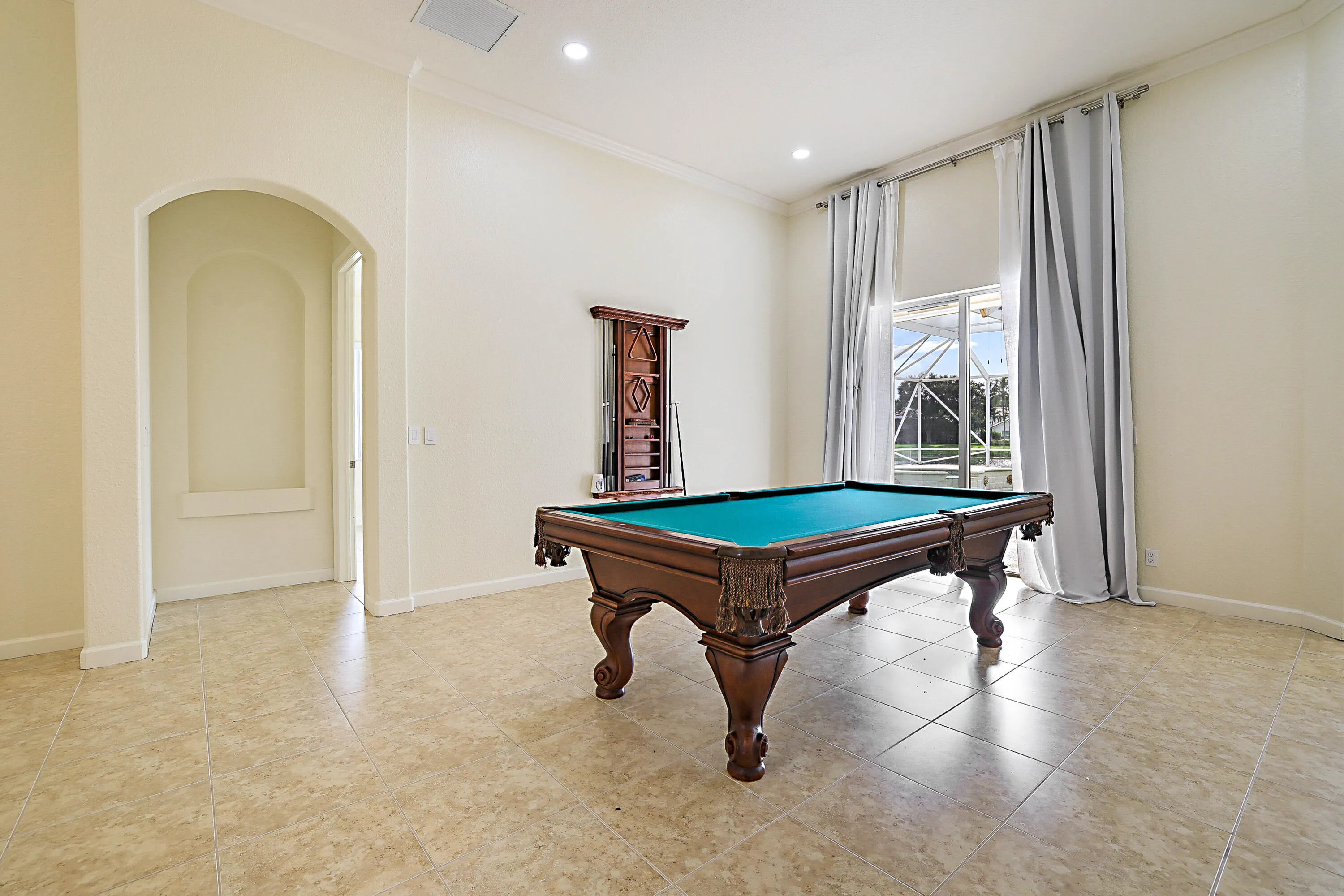 Recessed lighting, arched doorway, crown molding, tiled flooring, and sliding glass doors