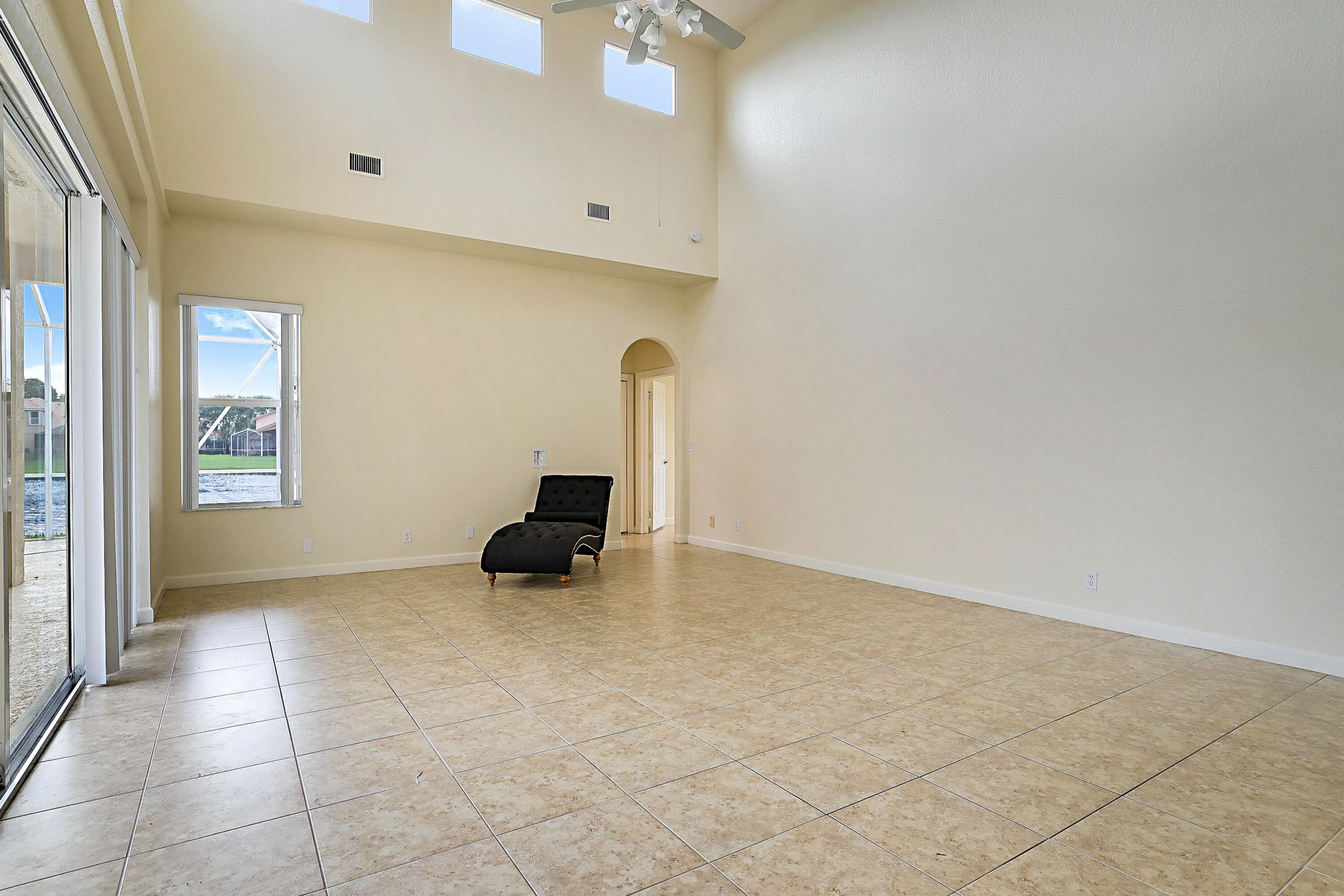 Spacious room featuring vaulted ceilings, transom windows, and tile flooring