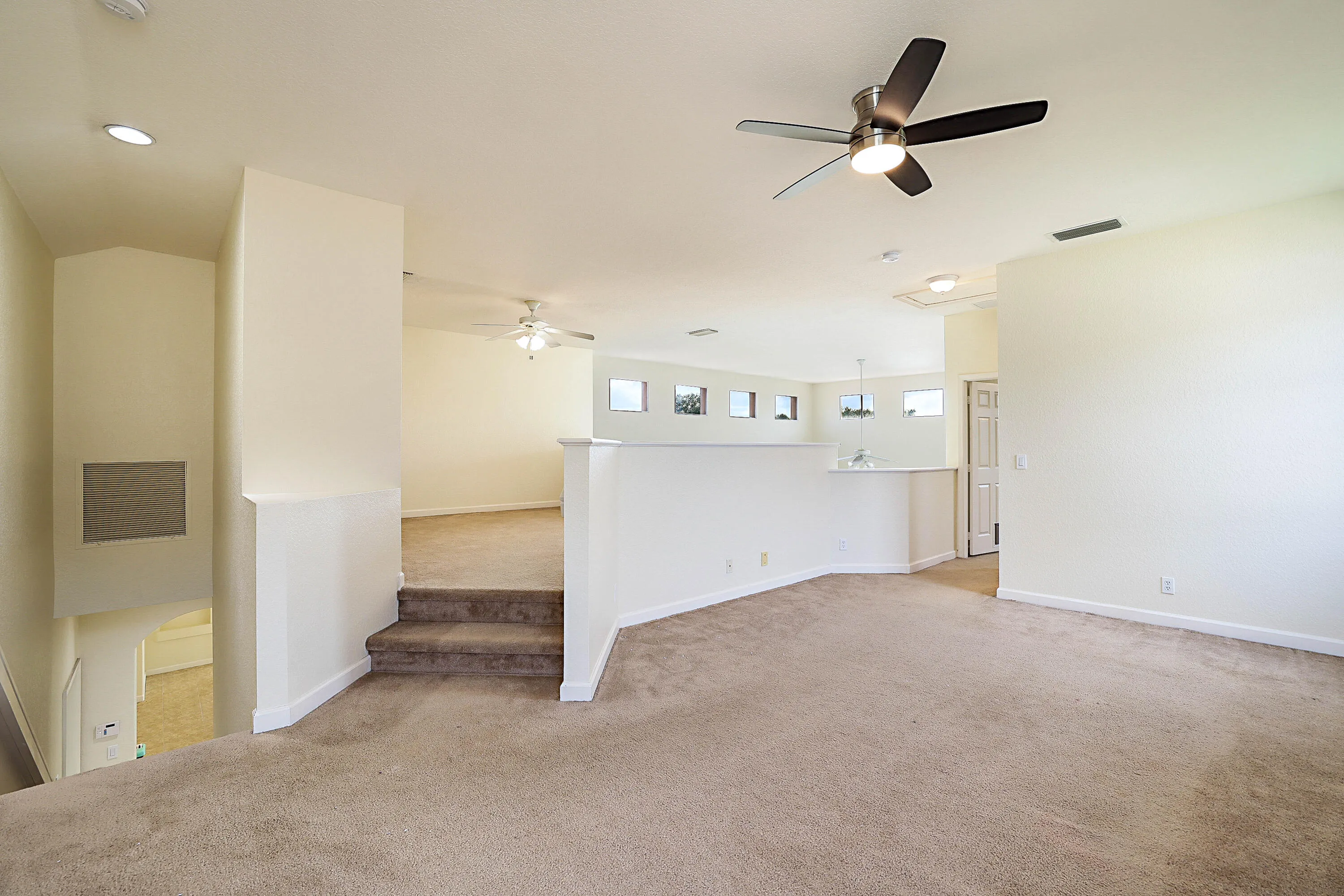 Open-concept upper level featuring carpet flooring, recessed lighting, and a ceiling fan