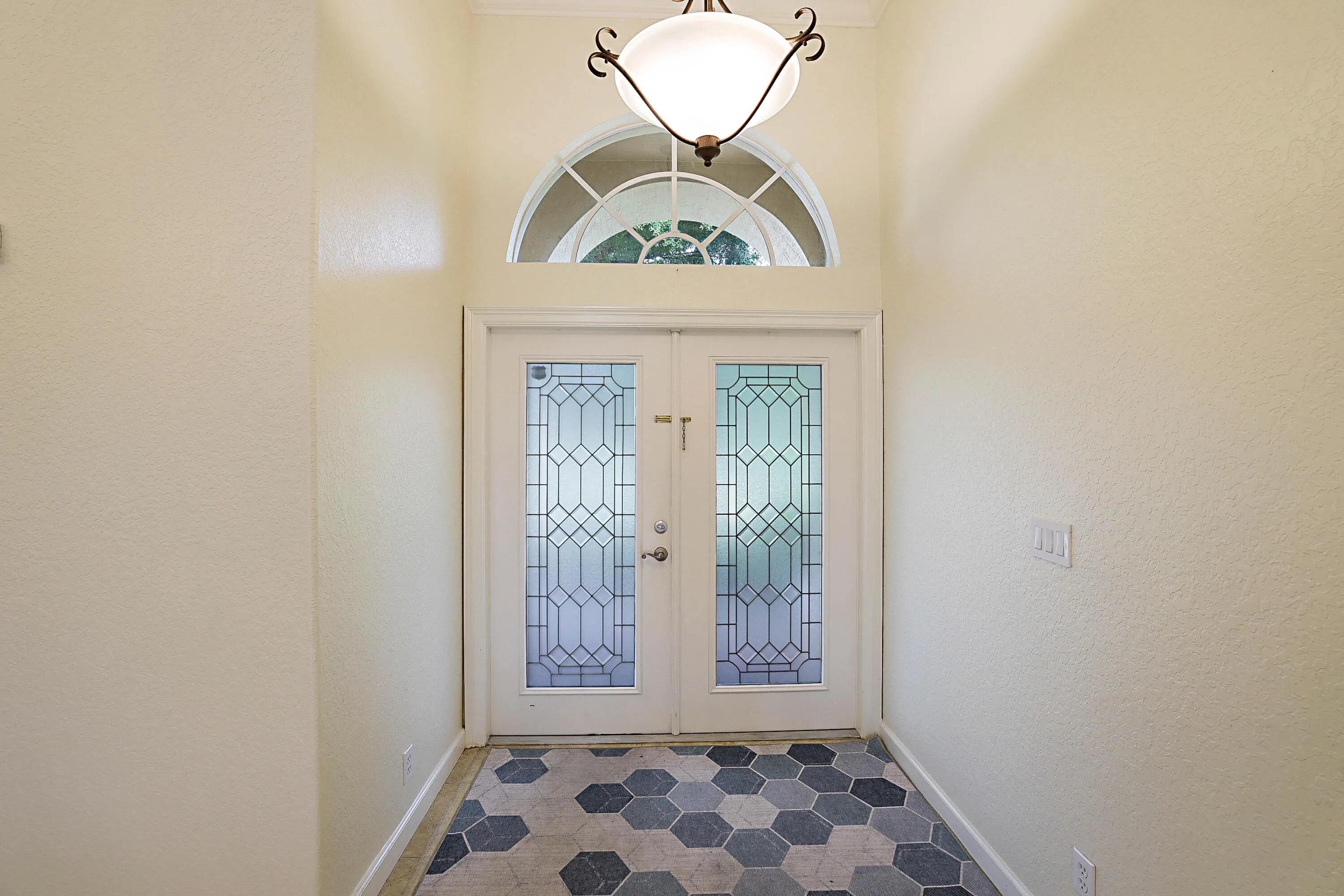 Double entry doors featuring decorative glass panels