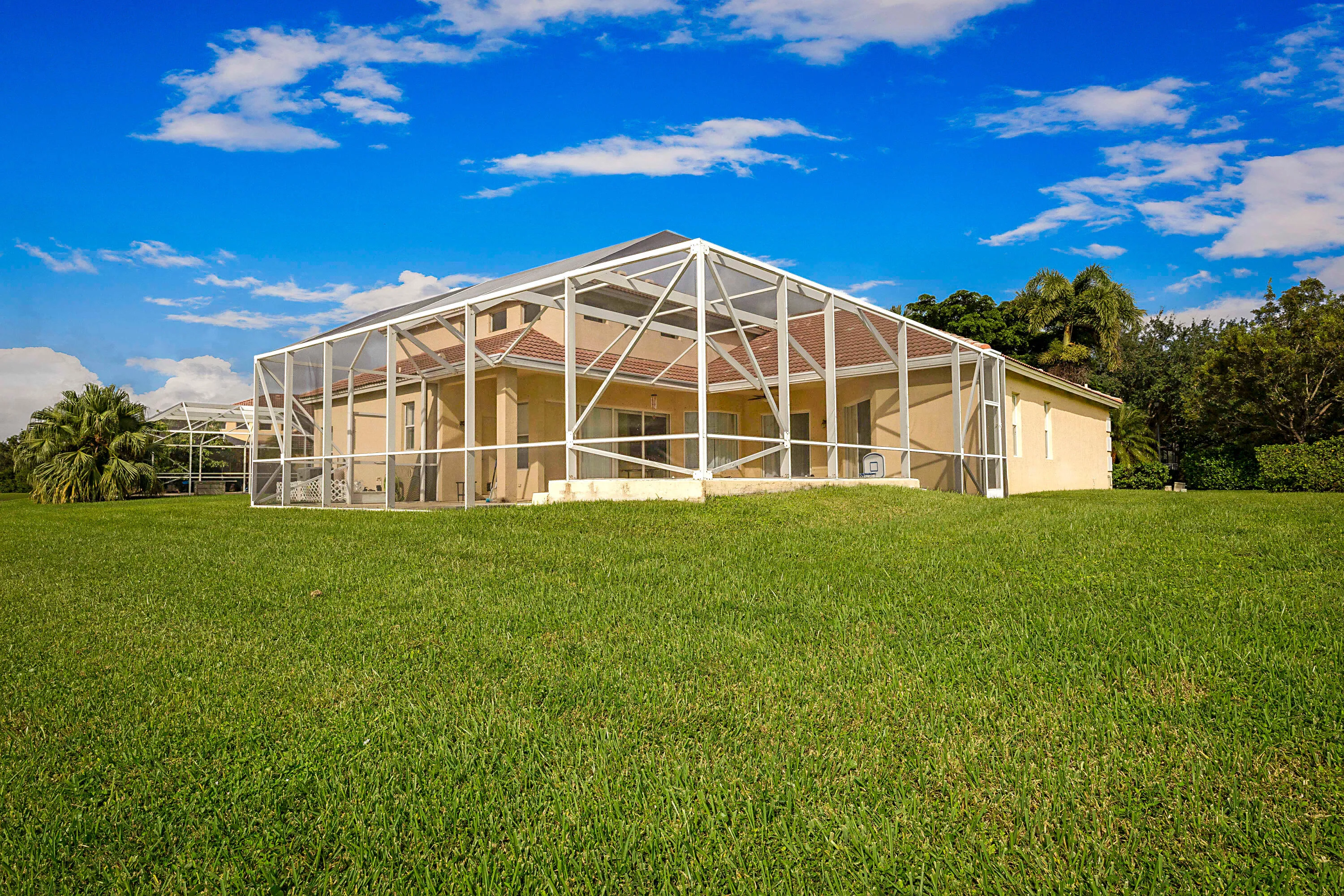 Modern architectural residence featuring a striking geometric steel frame structure with expansive glass panels, complemented by warm-toned exterior cladding