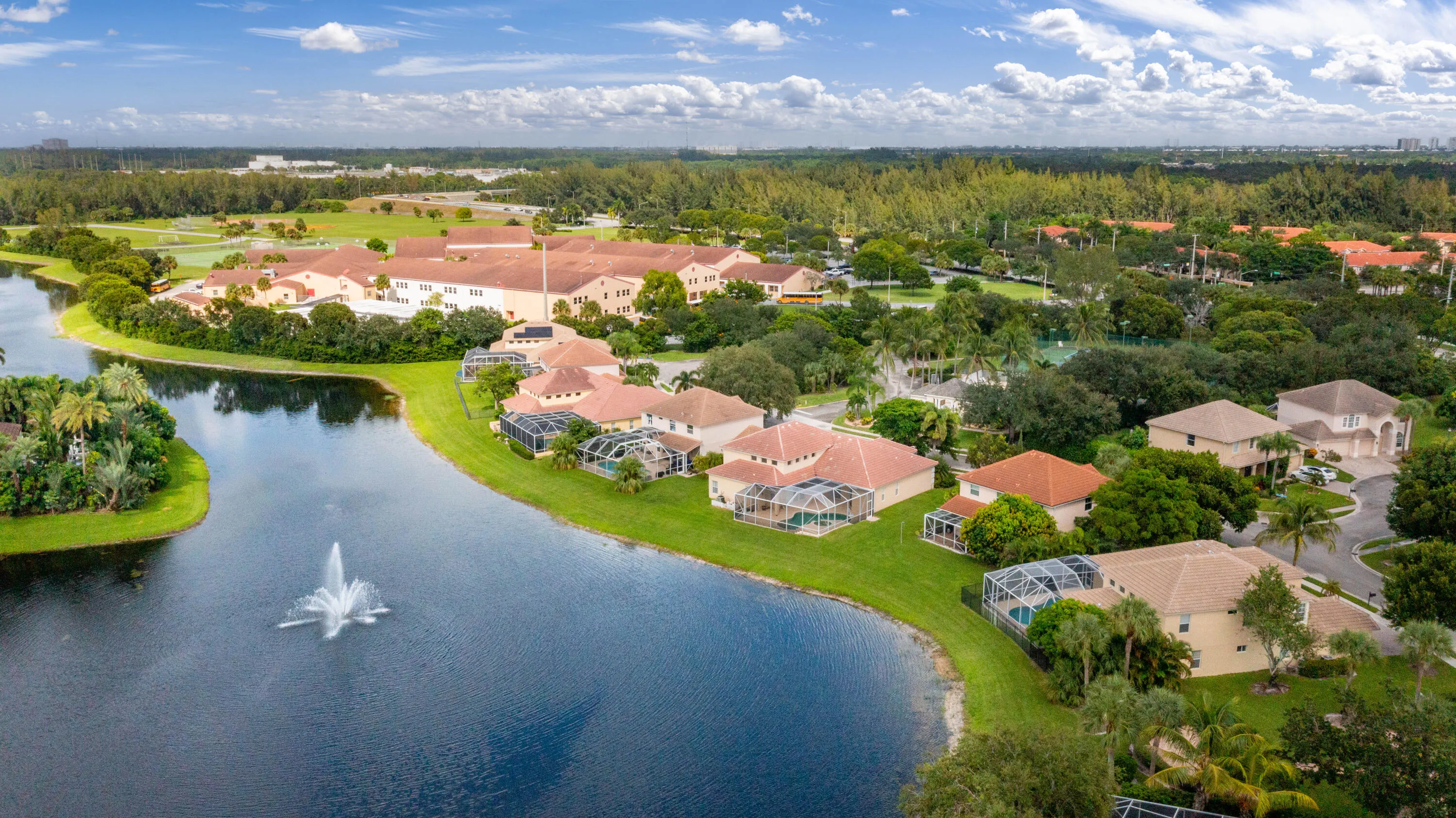 Waterfront residences featuring private screened pools, mature landscaping, and tile roofs