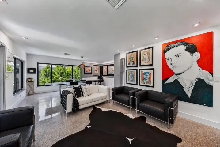 Expansive living area with polished aggregate flooring, recessed lighting, and large windows