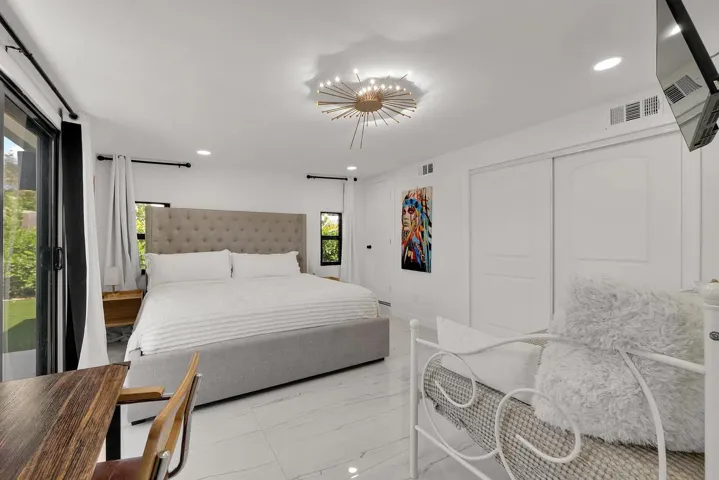White tile flooring, sliding glass patio door, recessed lighting, ceiling light fixture, and white sliding closet doors