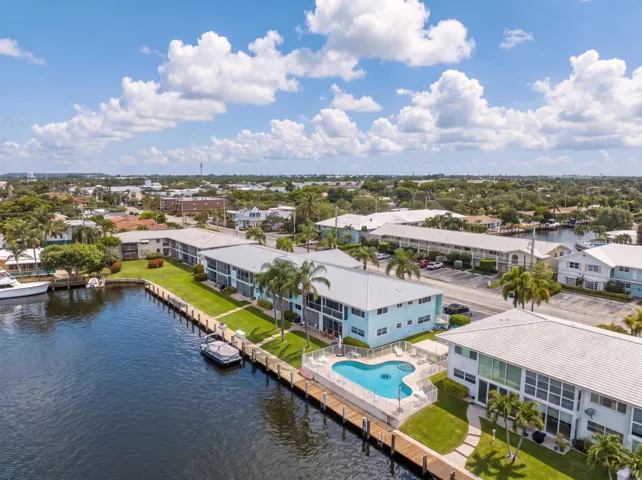 Waterfront property with private boat docks, a swimming pool, and mature palm trees