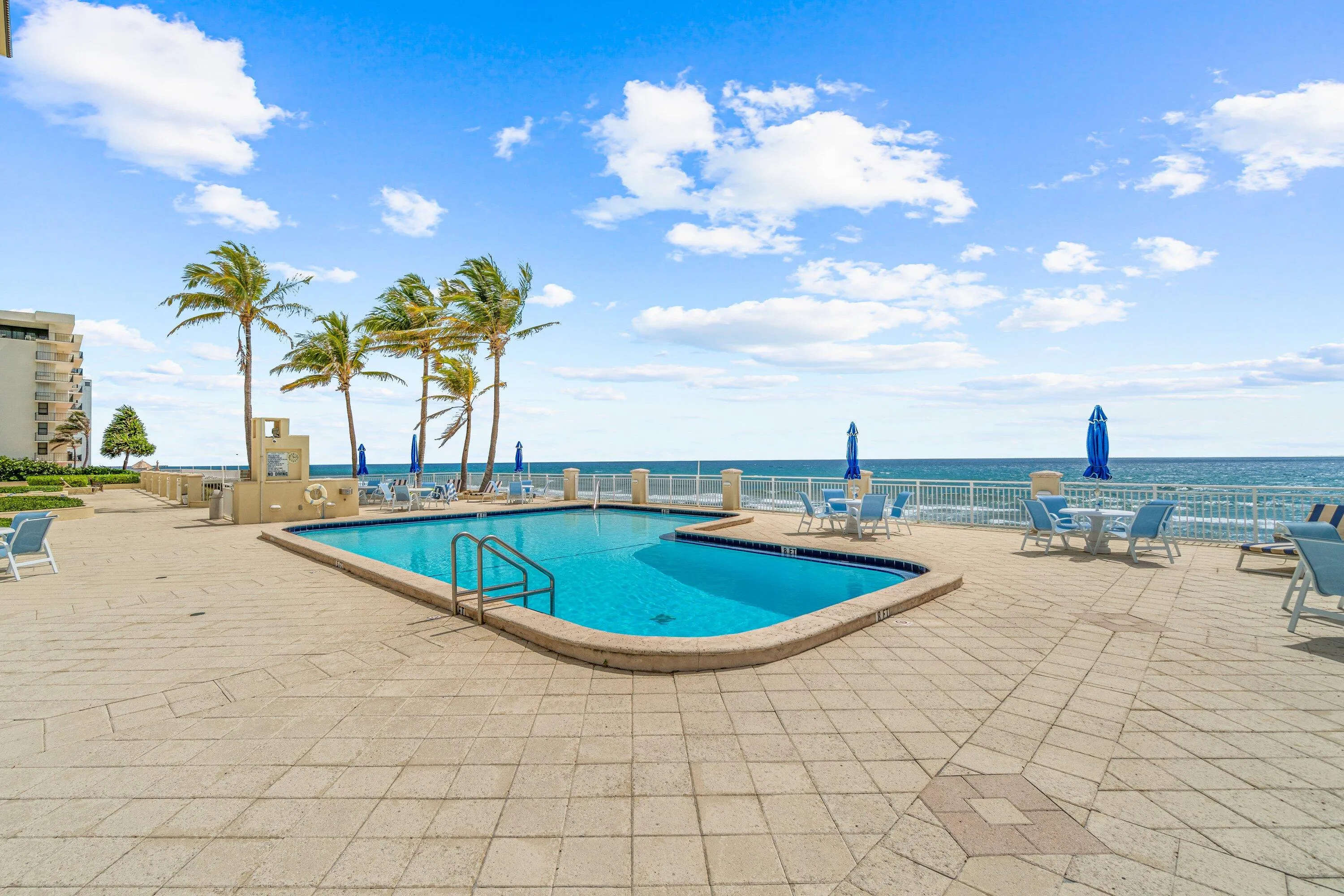 Expansive outdoor patio with a swimming pool, oceanfront setting