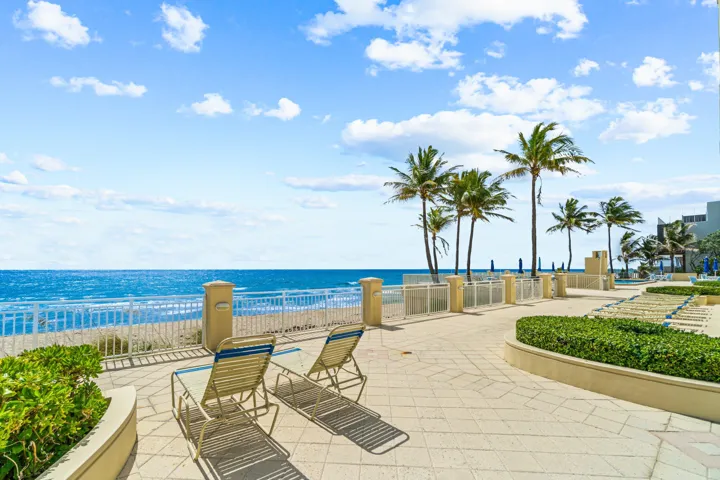 Waterfront patio with paver stone surfacing, low perimeter wall, and established landscaping