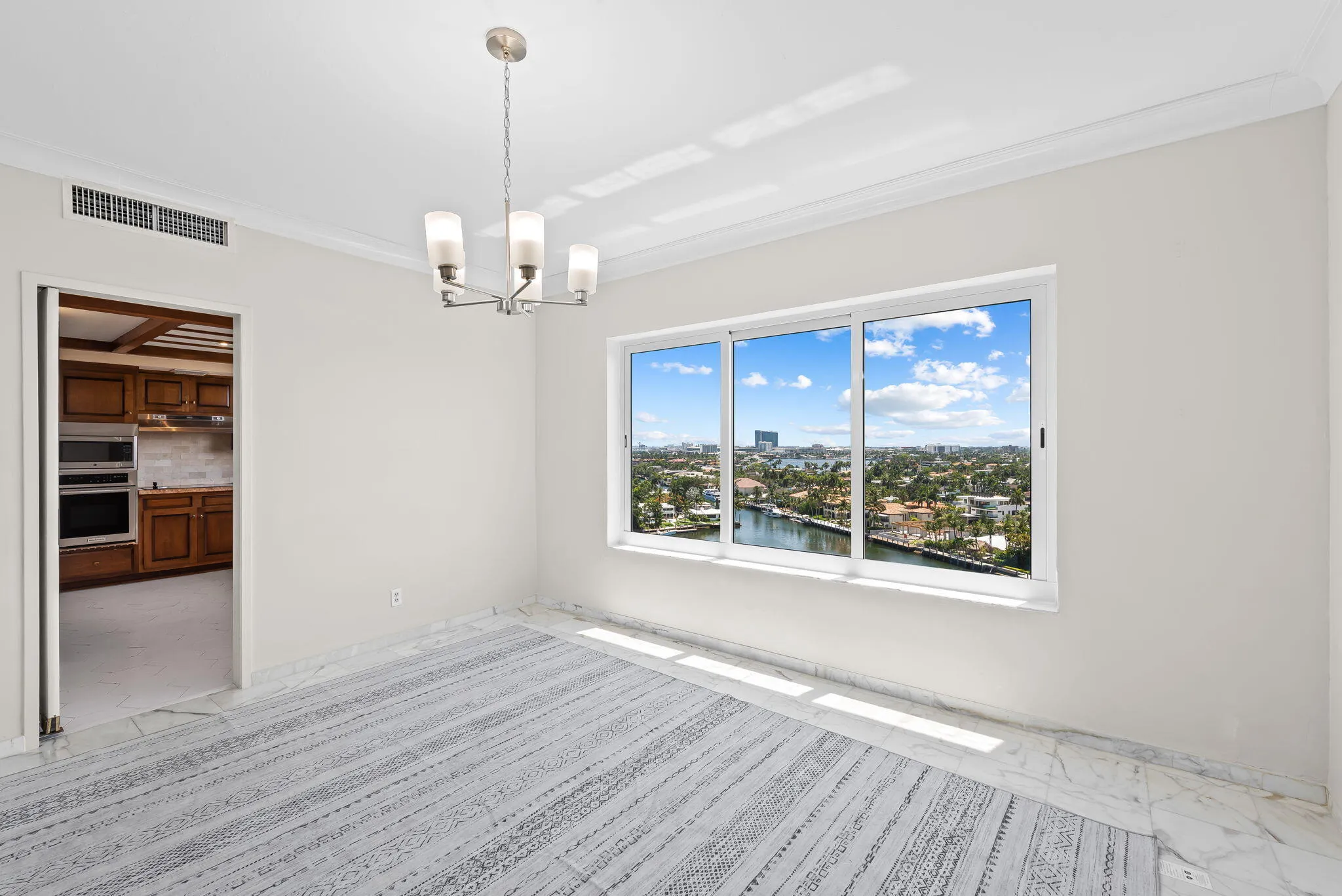 Dining room with view over the lake and las Olas waterfront homes - kitchen off to the side