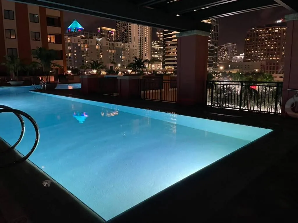 Swimming pool with underwater lighting, surrounded by a dark-toned deck