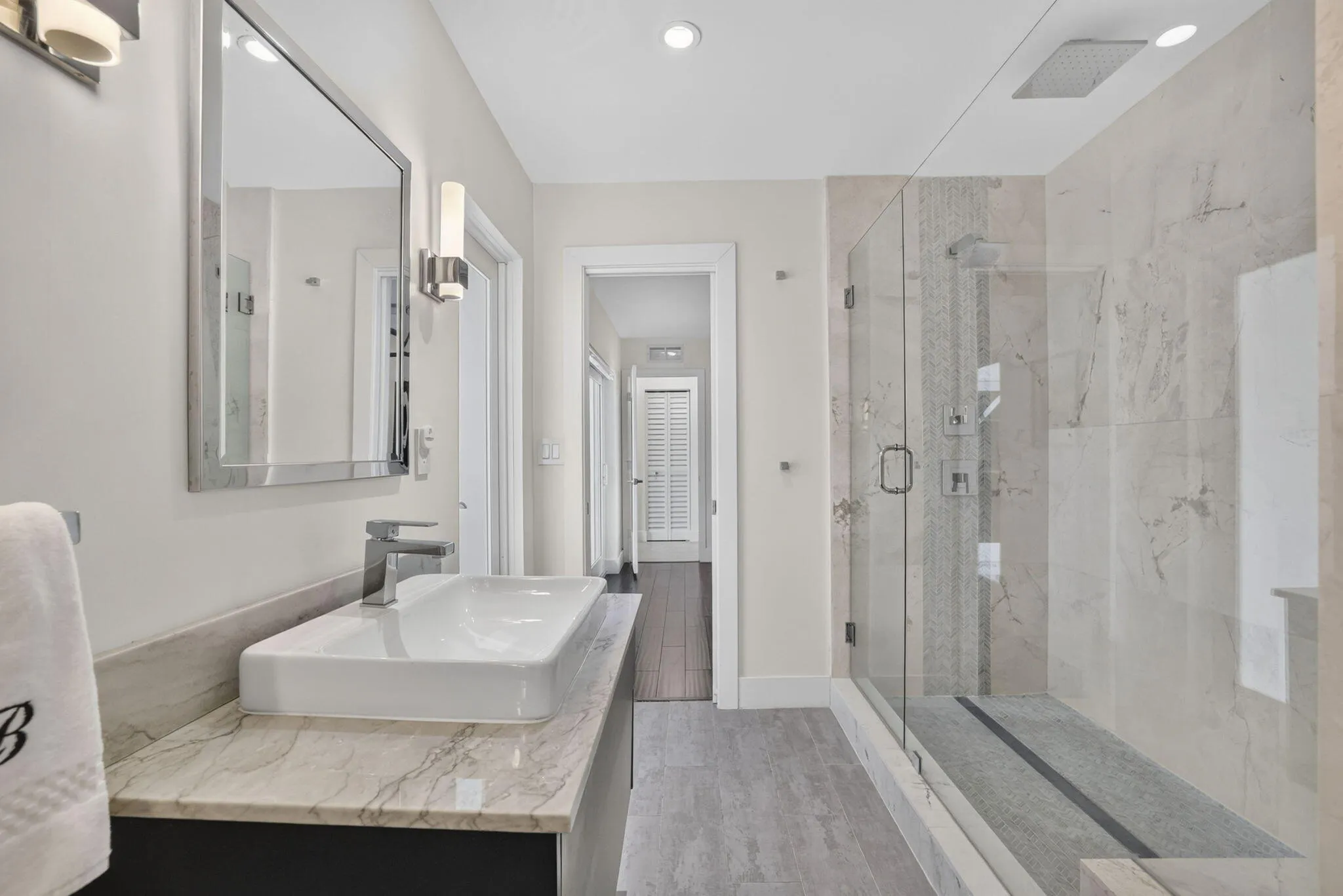 Floating vanity with a vessel sink, polished chrome faucet, and rectangular mirror