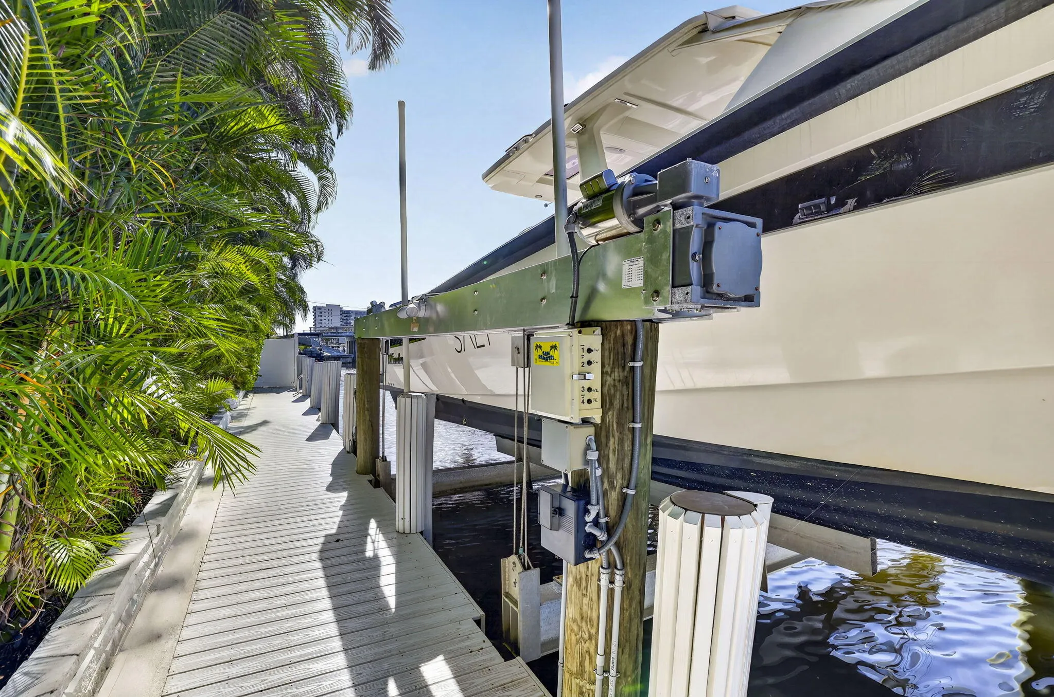 Private dock with wood-finish decking, and lush tropical landscaping