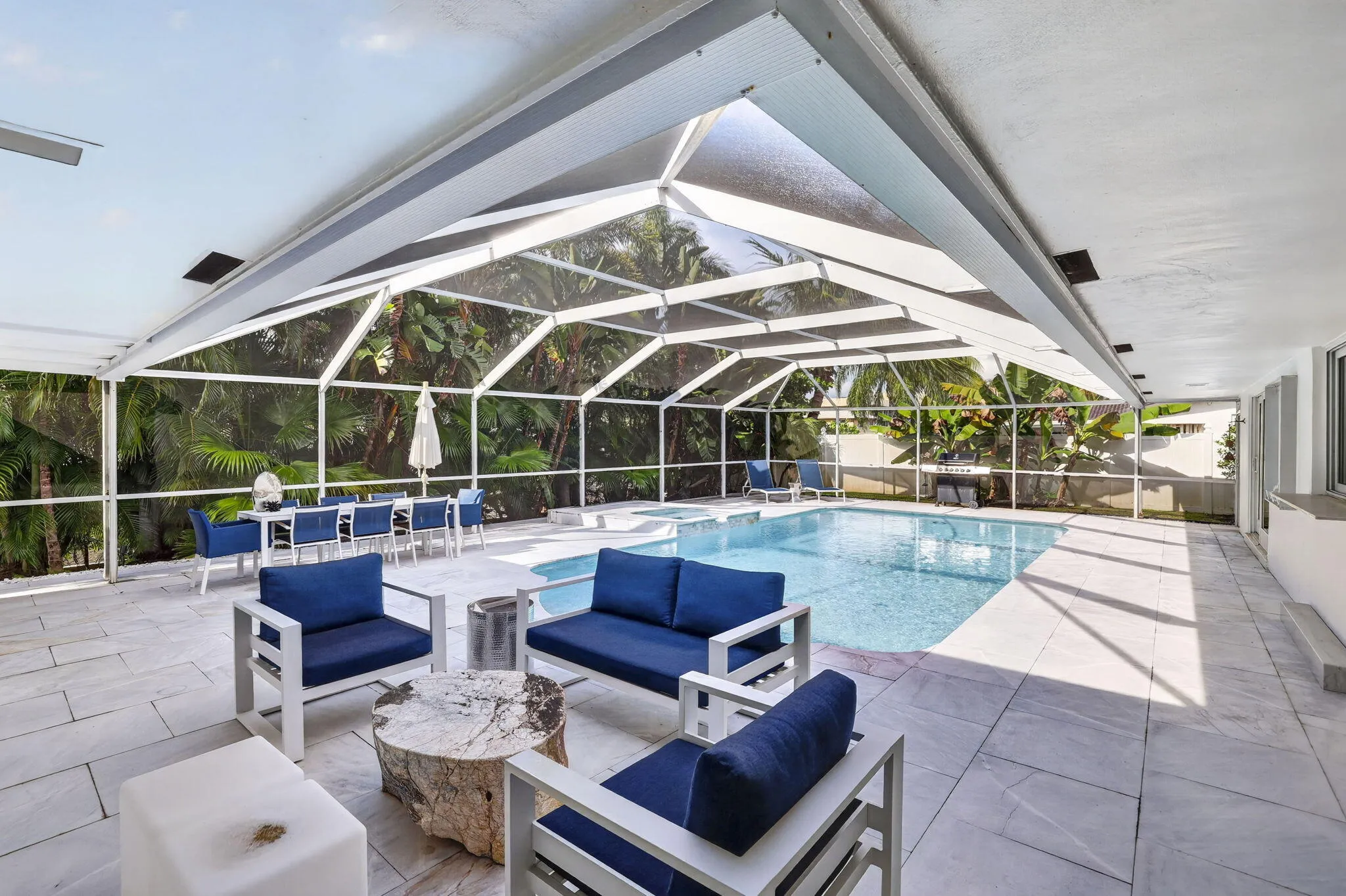 Screened outdoor space featuring a swimming pool, integrated spa, and expansive patio