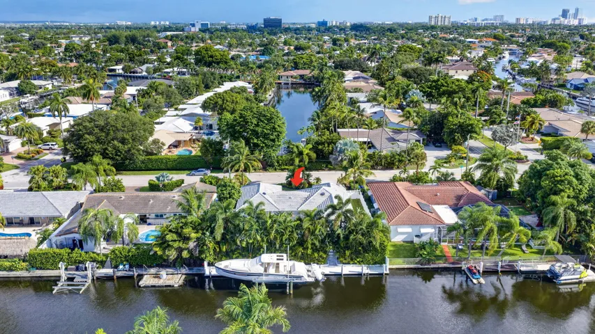 Waterfront property with private dock, lush landscaping, and a broad canal
