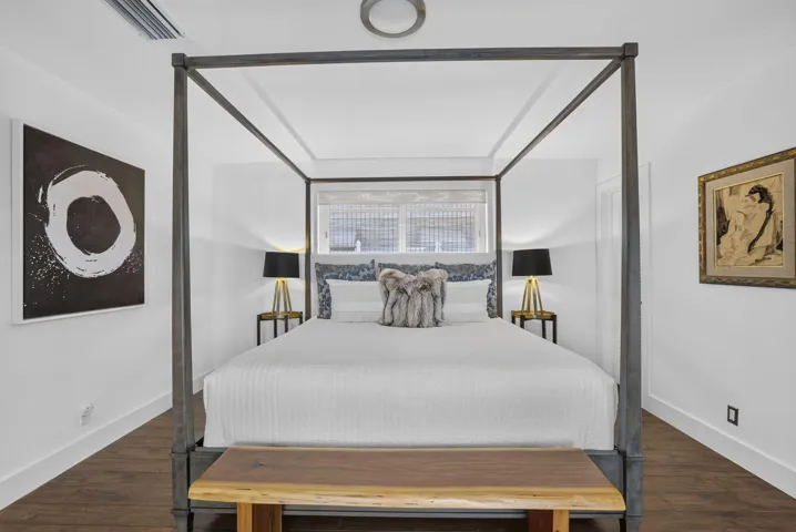 Wood-finish flooring, white walls, and a recessed tray ceiling