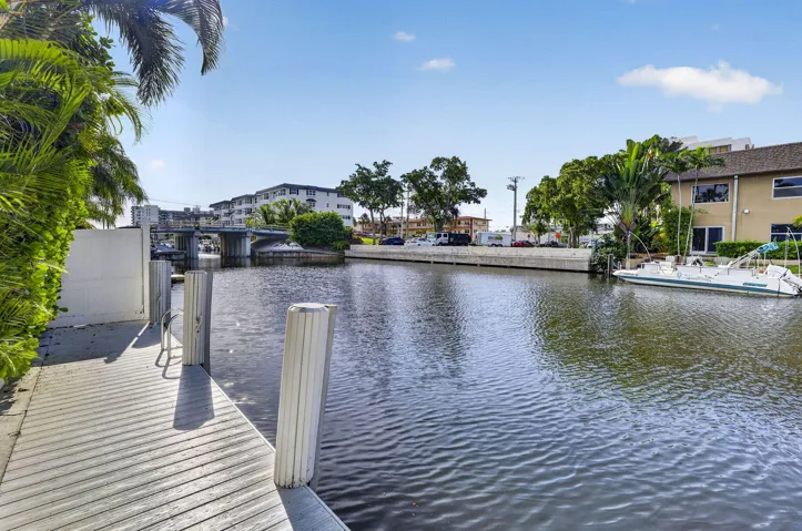 Waterfront property featuring a private dock, canal access, and lush landscaping