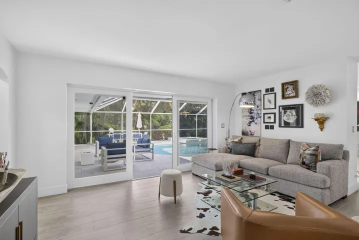 Sliding glass doors opening to a screened lanai with a swimming pool and spa