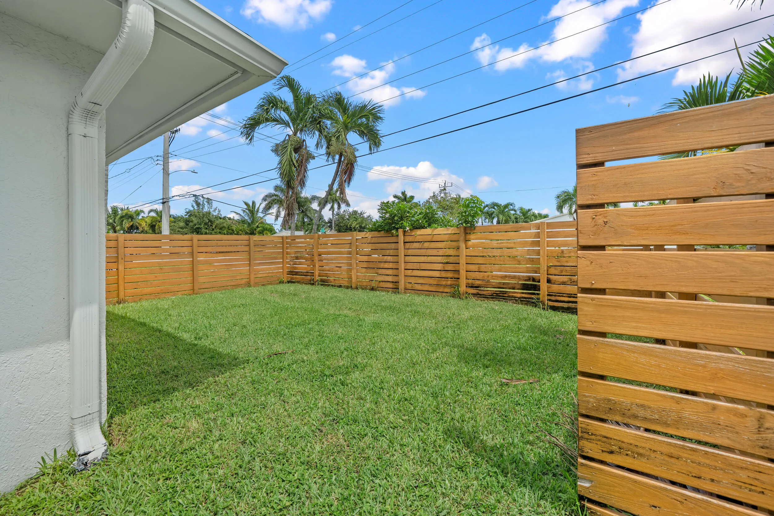 Private backyard with wood plank fencing and a grass lawn
