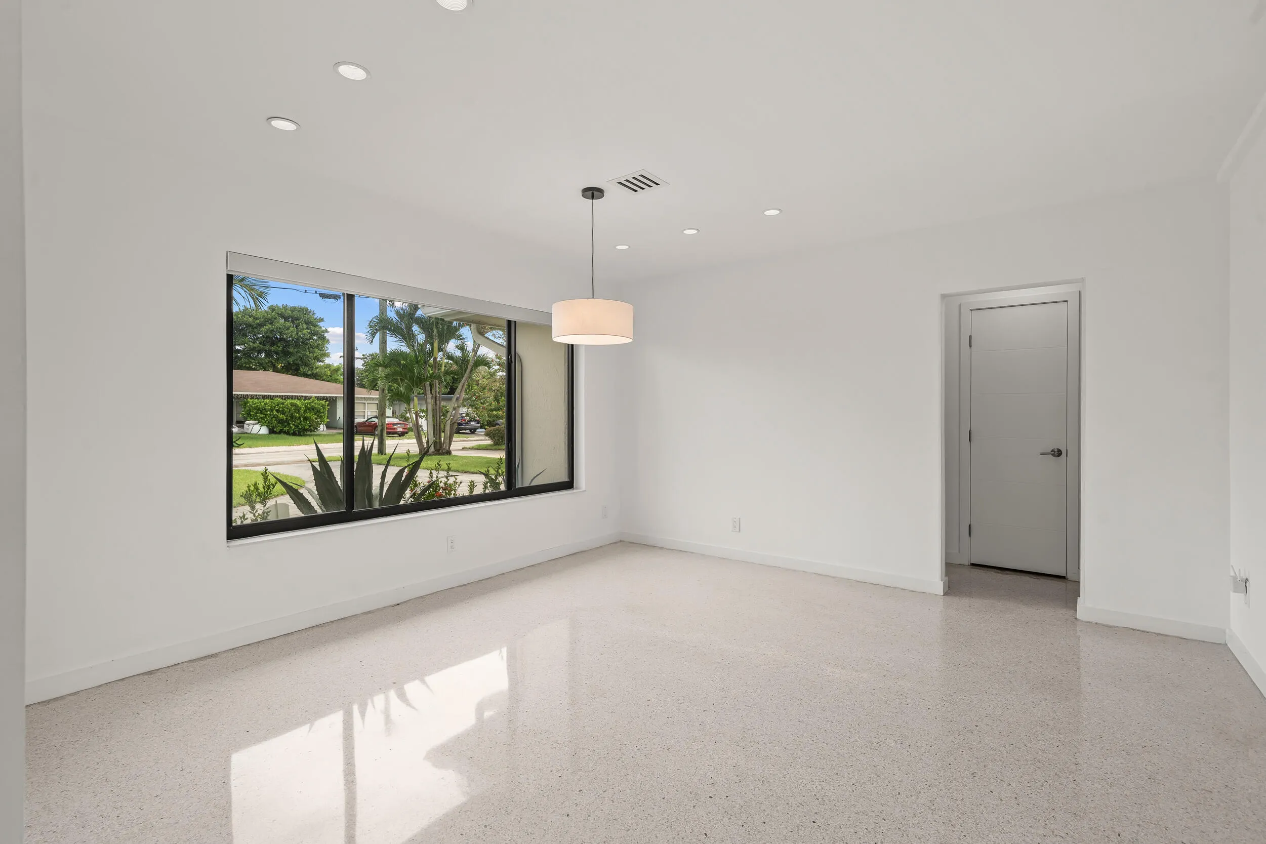 Spacious room featuring light-toned terrazzo flooring and recessed lighting