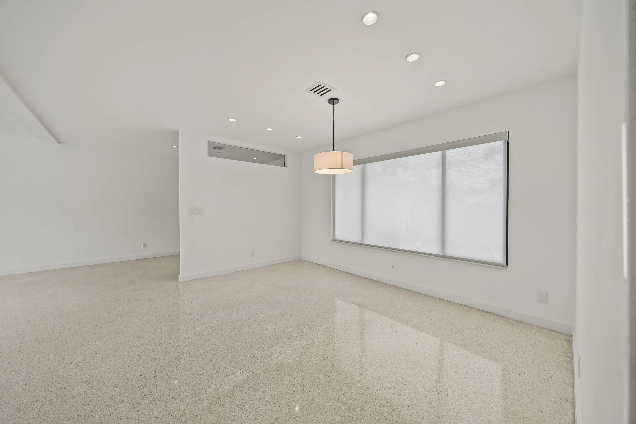 Recessed lighting, central pendant light fixture, and window with roller shade