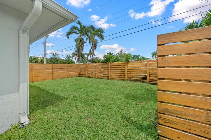 Private backyard with wood plank fencing and a grass lawn