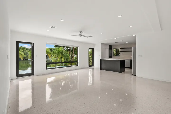 Polished concrete flooring, recessed lighting, and a modern ceiling fan complement the open-concept design