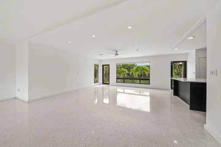 Expansive living area with large format terrazzo flooring, recessed lighting, and a modern ceiling fan